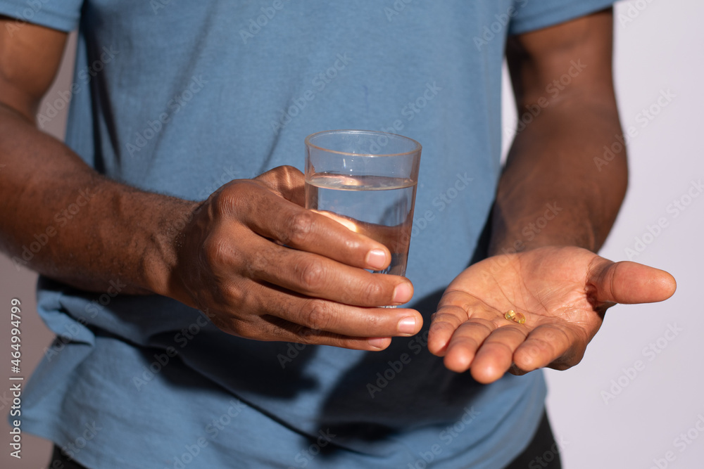 person holding his drugs and a glass of water close up person holding his drugs and a glass of water close up