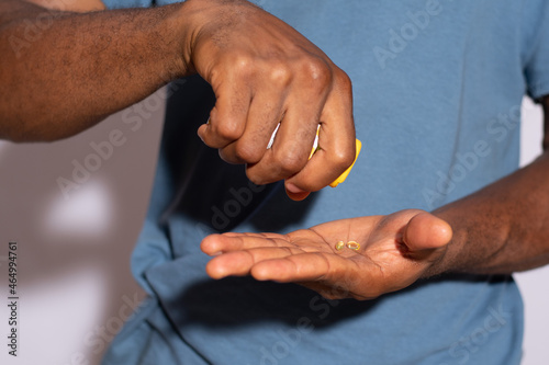 black man putting his drugs into his hand © Confidence
