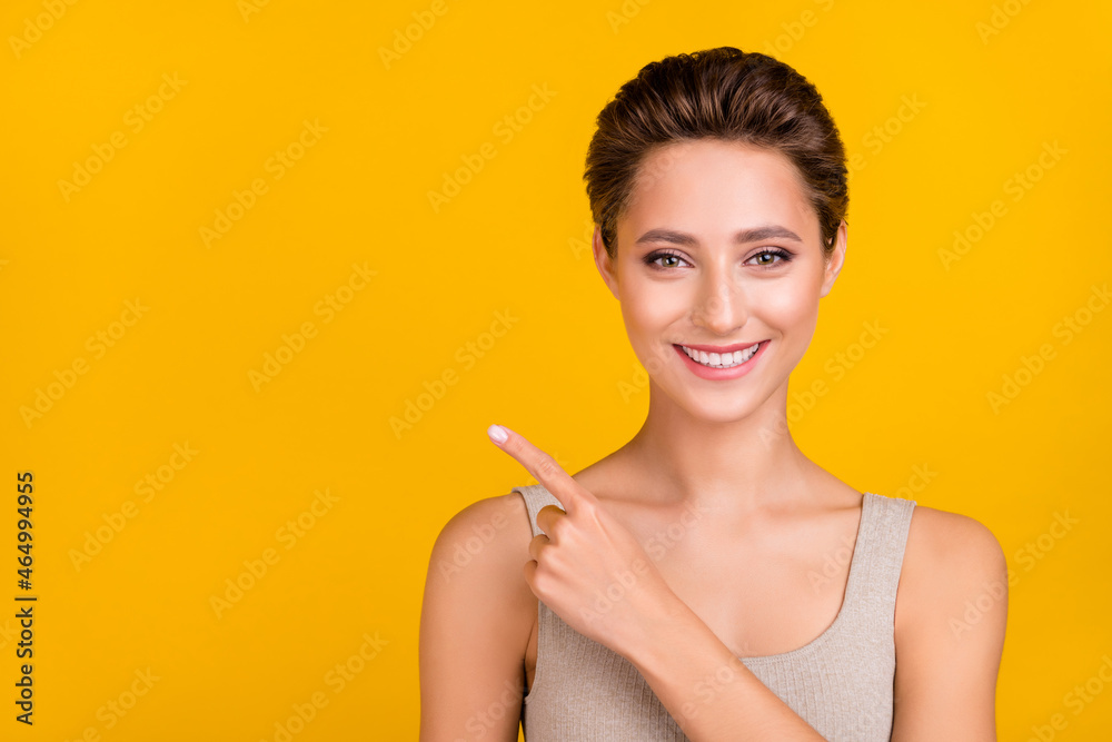 Photo of cheerful nice lady indicate forefinger empty space wear grey top isolated yellow color background Photo of cheerful nice lady indicate forefinger empty space wear grey top isolated yellow color background