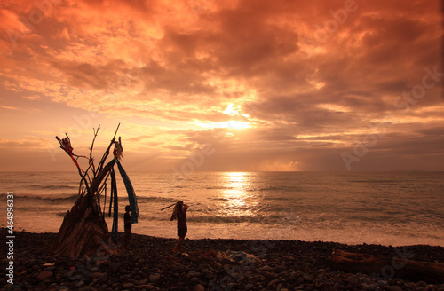 hippy on a beach with wooden shelter teepee with the ocean