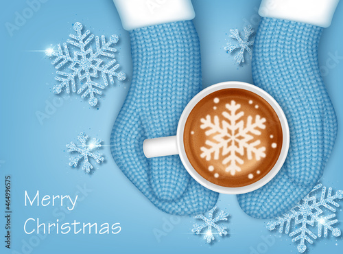 Hands in knitted mittens holding a cup of coffee. Christmas greeting card template
