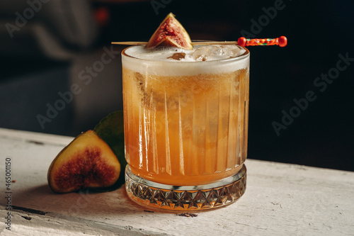 Whiskey sour cocktail with fig in old fashioned glass 