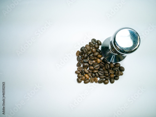 Coffee Beans, Heart Shape and  tamper on white table background photo