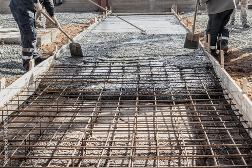 Photography Pouring cement or concrete with a concrete mixer truck, construction site with a reinforced grillage foundation, start of construction of a production workshop