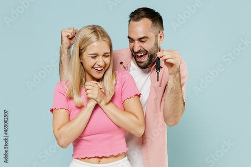 Young happy couple two friends family man woman in casual clothes together gift car key do winner gesture isolated on pastel plain light blue color background studio portrait People lifestyle concept.