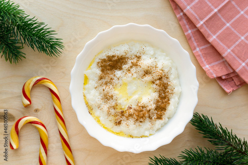Christmas rice porridge with butter and cinnamon on wooden background, top view