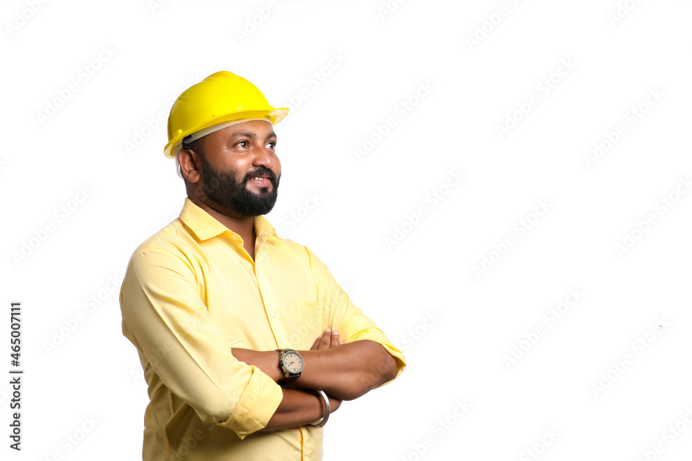 Young Indian engineer wearing yellow color hard hat on white background. Young Indian engineer wearing yellow color hard hat on white background.