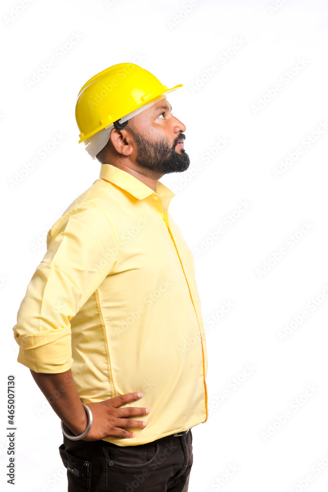 Young Indian engineer wearing yellow color hard hat on white background. Young Indian engineer wearing yellow color hard hat on white background.