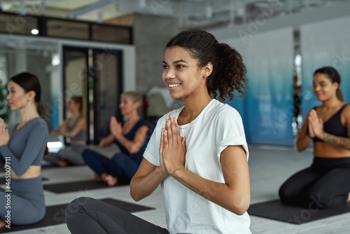 Active smiling girl meditate practice yoga at group training