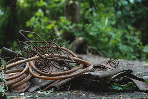 pile of garbage with rusty metal and wires in polluted park