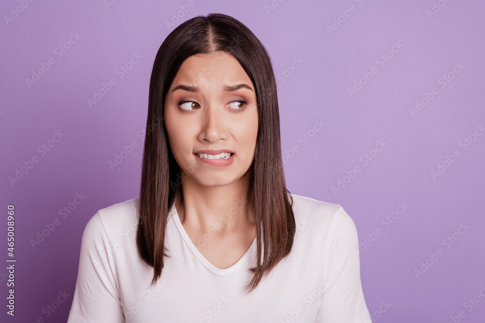 Photo of young woman unhappy sad upset negative moody bite lips teeth fail isolated over violet color background Photo of young woman unhappy sad upset negative moody bite lips teeth fail isolated over violet color background