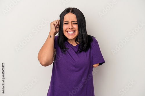Young caucasian woman with one arm isolated on white background covering ears with hands. © Asier