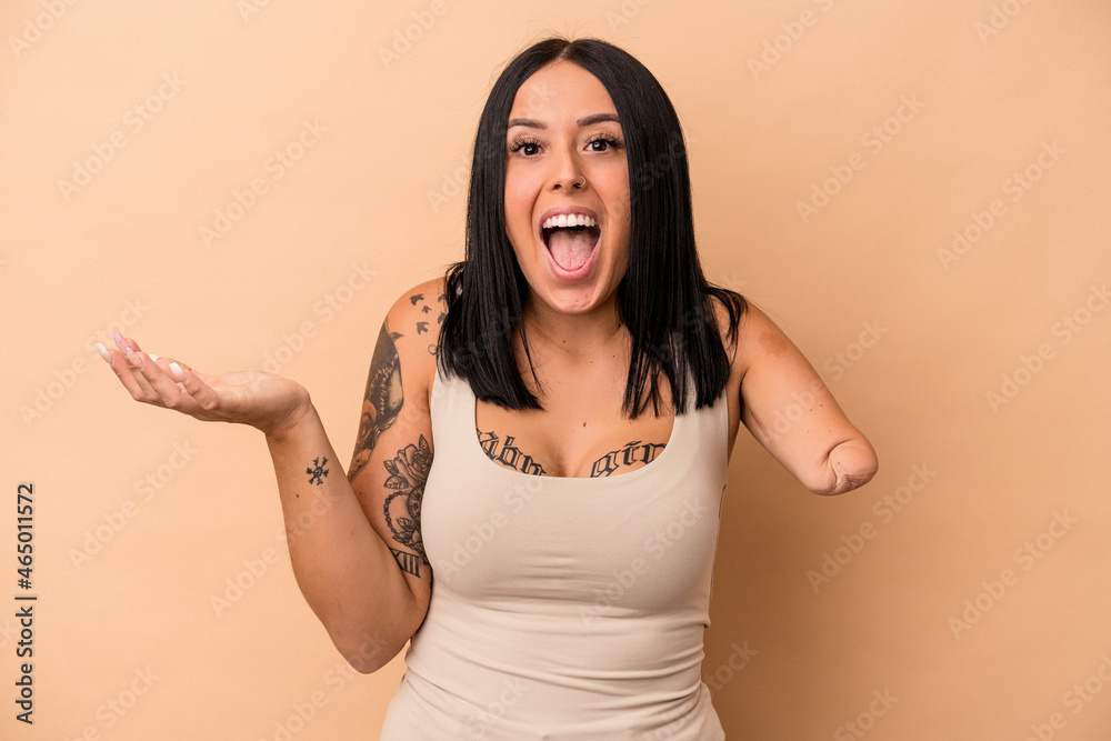 Young caucasian woman with one arm isolated on beige background receiving a pleasant surprise, excited and raising hands. Young caucasian woman with one arm isolated on beige background receiving a pleasant surprise, excited and raising hands.