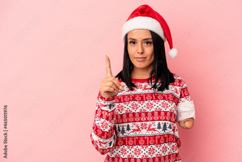 Young caucasian woman with one arm celebrating Christmas isolated on pink background showing number one with finger. Young caucasian woman with one arm celebrating Christmas isolated on pink background showing number one with finger.