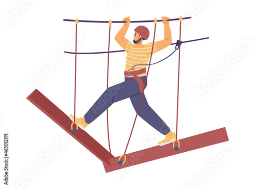 Man in helmet, with climbing harness, is walking along obstacle course