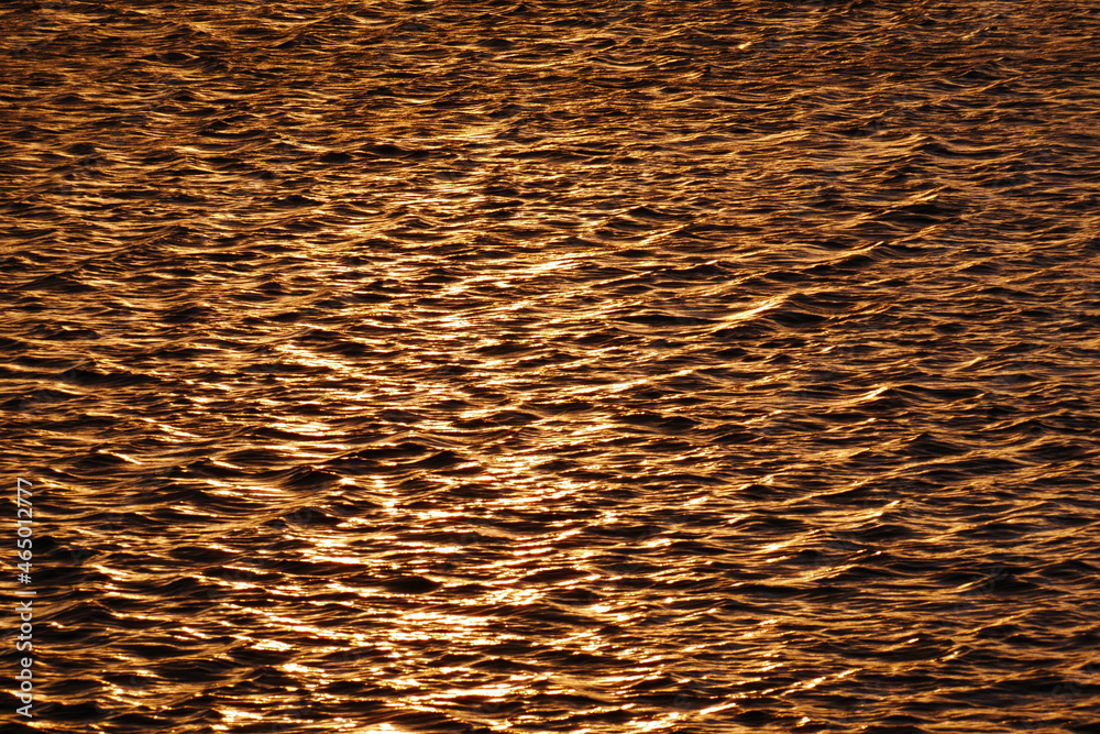 gold shimmering waves of a lake at sunset gold shimmering waves of a lake at sunset