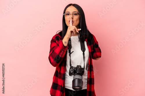 Young caucasian photography woman with one arm isolated on pink background keeping a secret or asking for silence.