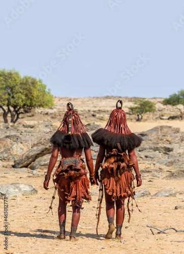 Two women of the Himba tribe are walking in the desert.