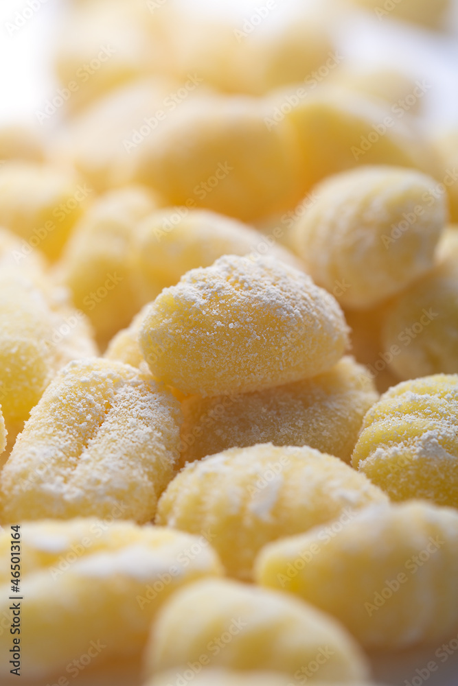 Raw italian gnocchi on a white background, close up shot, selective focus Raw italian gnocchi on a white background, close up shot, selective focus