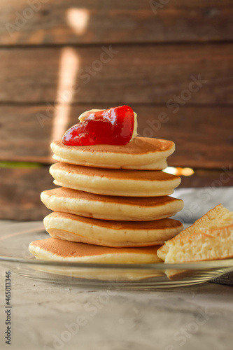 pancake slide with strawberry jam on top. on a wooden background