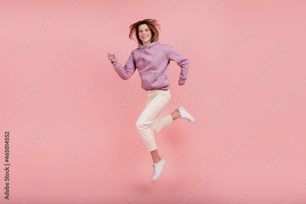 Full length profile side photo of mature woman good mood jumper casual outfit runner isolated pink color background