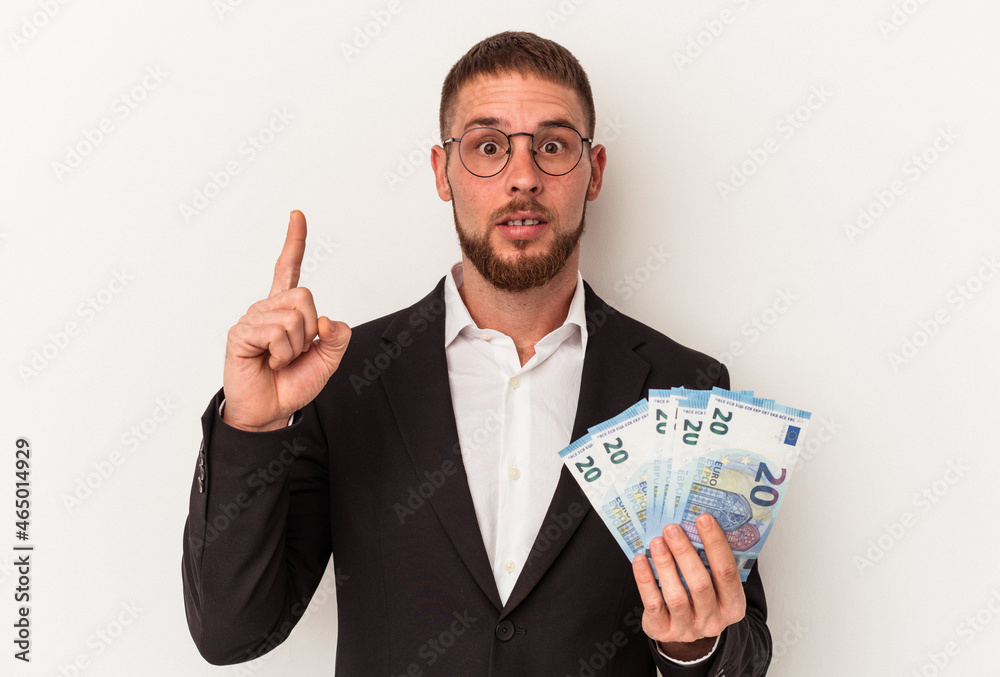 Young business caucasian man holding banknotes isolated on white background having some great idea, concept of creativity. Young business caucasian man holding banknotes isolated on white background having some great idea, concept of creativity.