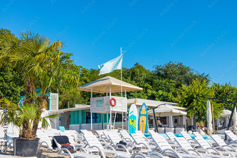 Lifeguard post with sun loungers on the beach on sunny vacation day