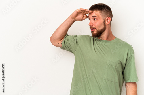 Young caucasian man with diastema isolated on white background looking far away keeping hand on forehead.