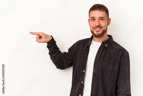 Young caucasian man with diastema isolated on white background smiling cheerfully pointing with forefinger away.