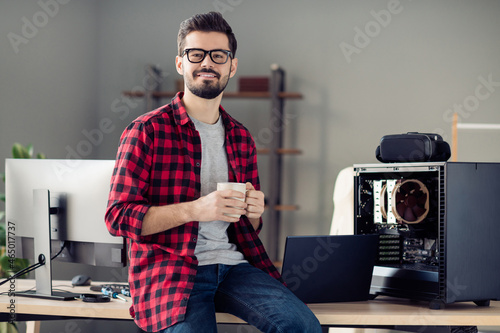 Foto Portrait of nice attractive smart clever cheerful guy sitting on table drinking