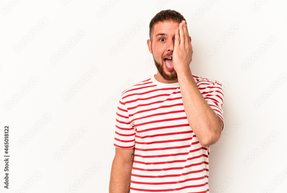 Young caucasian man with diastema isolated on white background having fun covering half of face with palm. Young caucasian man with diastema isolated on white background having fun covering half of face with palm.
