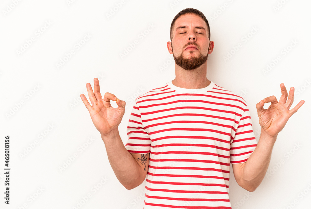 Young caucasian man with diastema isolated on white background relaxes after hard working day, she is performing yoga. Young caucasian man with diastema isolated on white background relaxes after hard working day, she is performing yoga.