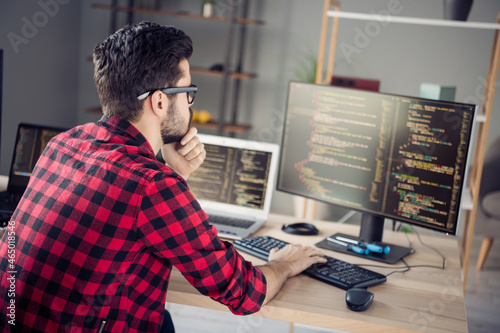 Profile side view portrait of attractive skilled focused guy writing html code css language php at work place station indoors photo