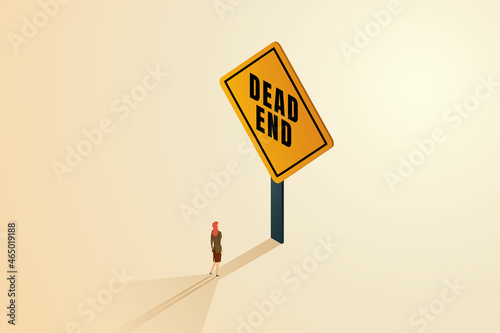 Businesswoman standing in front of a dead end sign.