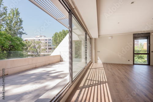 Fantastic terrace with large windows that join it to a bright living room in an empty apartment © Toyakisfoto.photos