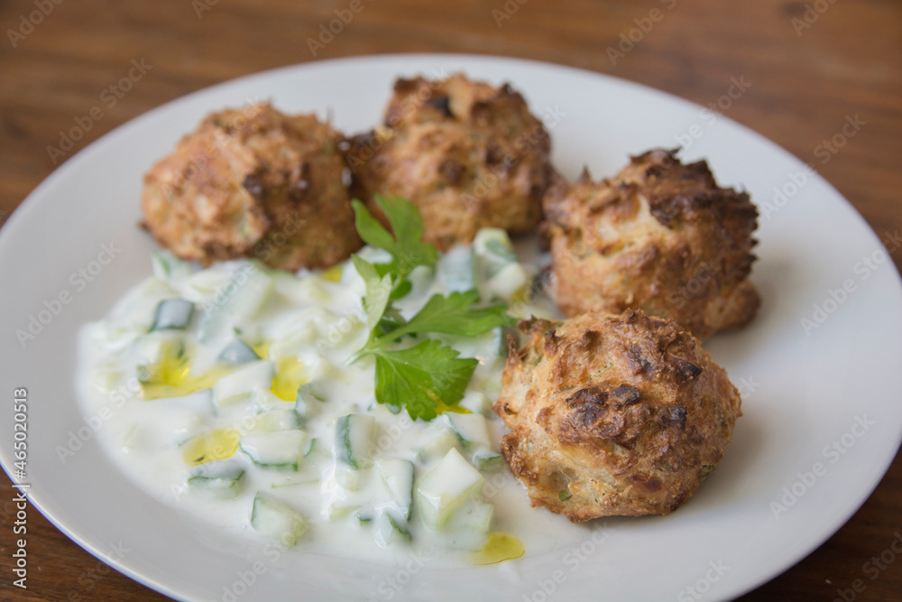 Traditional Greek patties, made of leek and cheese, served with Tzatziki sauce in a plate Traditional Greek patties, made of leek and cheese, served with Tzatziki sauce in a plate