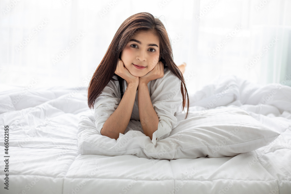 Asian woman Beautiful young smiling woman sitting and sleeping in white bed and stretching in the morning at bedroom after waking up in her bed fully rested Asian woman Beautiful young smiling woman sitting and sleeping in white bed and stretching in the morning at bedroom after waking up in her bed fully rested