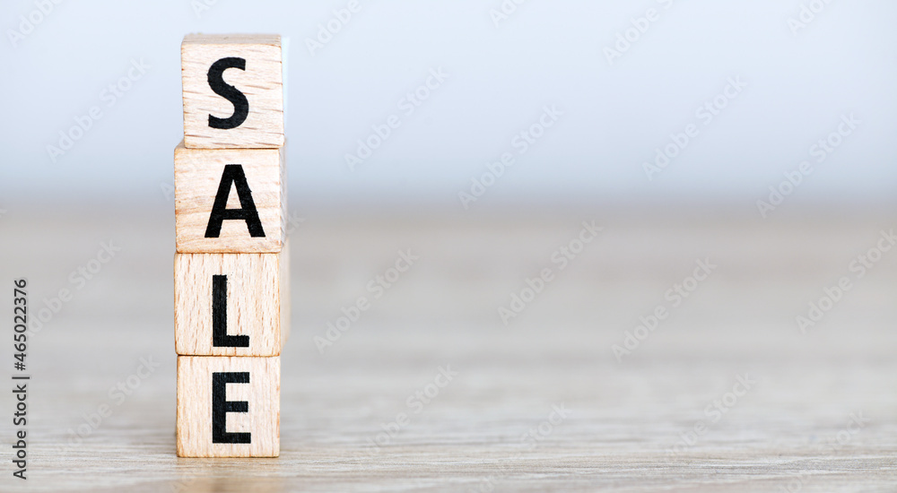 SALE words stacked with wooden letters on a wooden table. SALE words stacked with wooden letters on a wooden table.