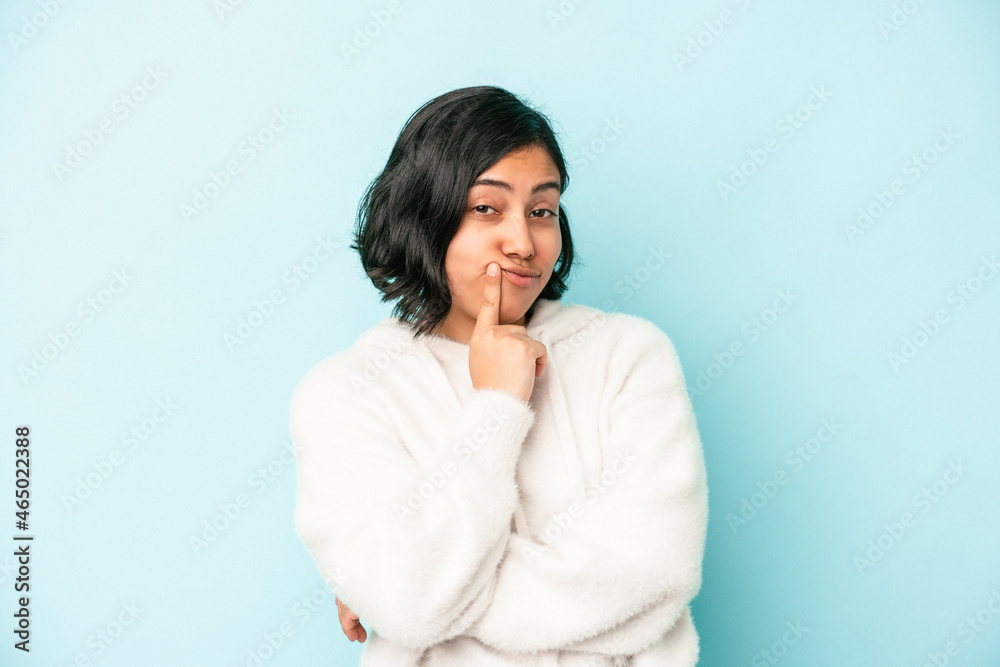 Young latin woman isolated on blue background contemplating, planning a strategy, thinking about the way of a business. Young latin woman isolated on blue background contemplating, planning a strategy, thinking about the way of a business.