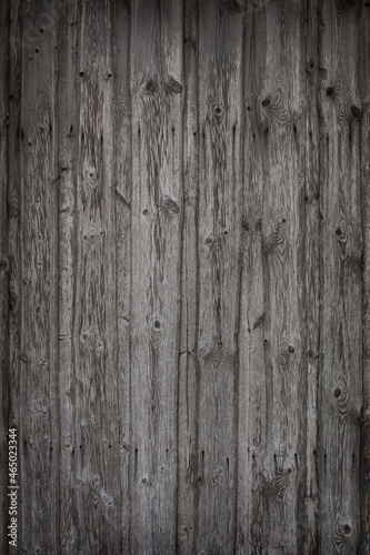 fragment of a fence made of old wooden boards with remnants of paint and nails, natural texture, background