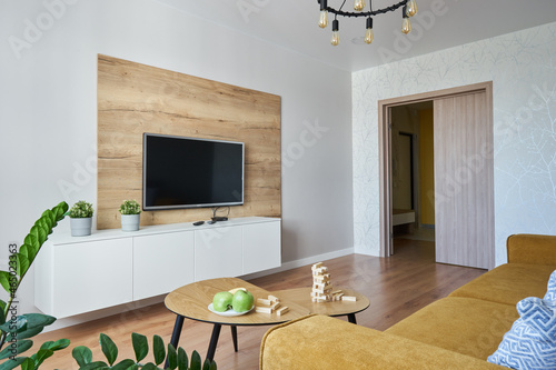 TV area with wooden decor and a yellow Scandinavian-style sofa