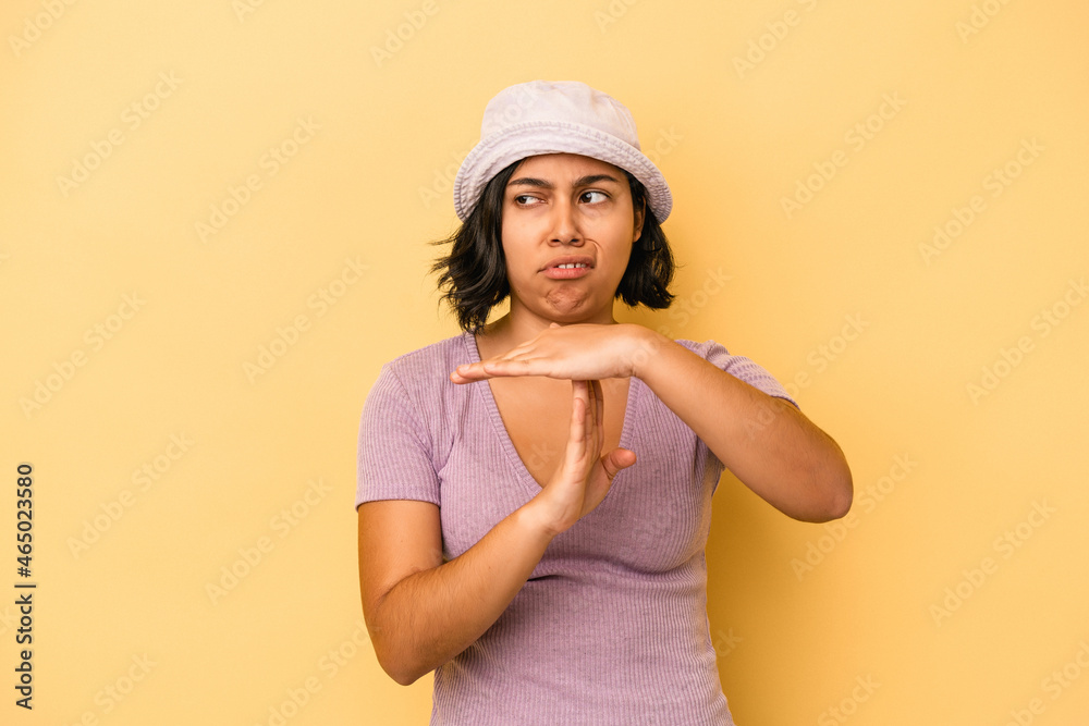 Young latin woman isolated on yellow background showing a timeout gesture. Young latin woman isolated on yellow background showing a timeout gesture.
