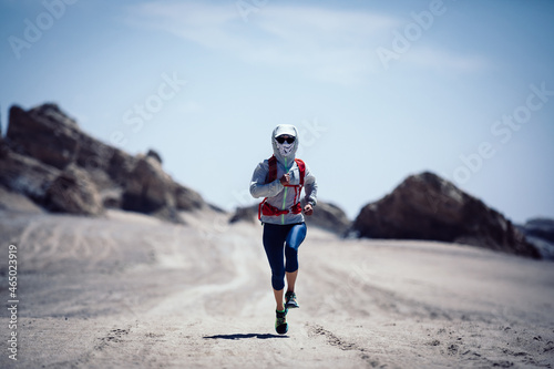 Fitness woman trail runner cross country running on sand desert
