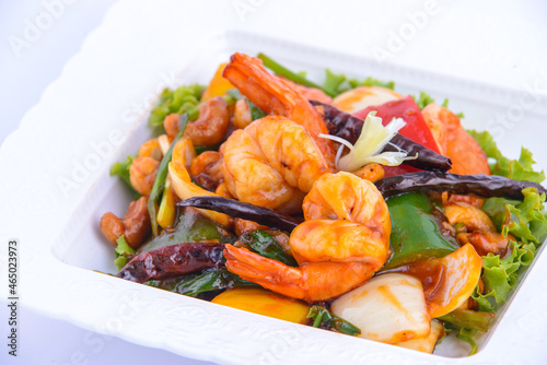 Sweet and sour shimp stir fried on the white dish.