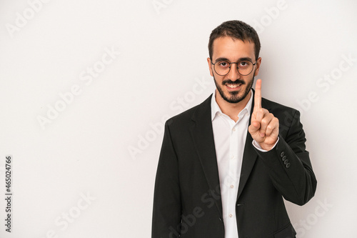 Young caucasian business man isolated on white background showing number one with finger.