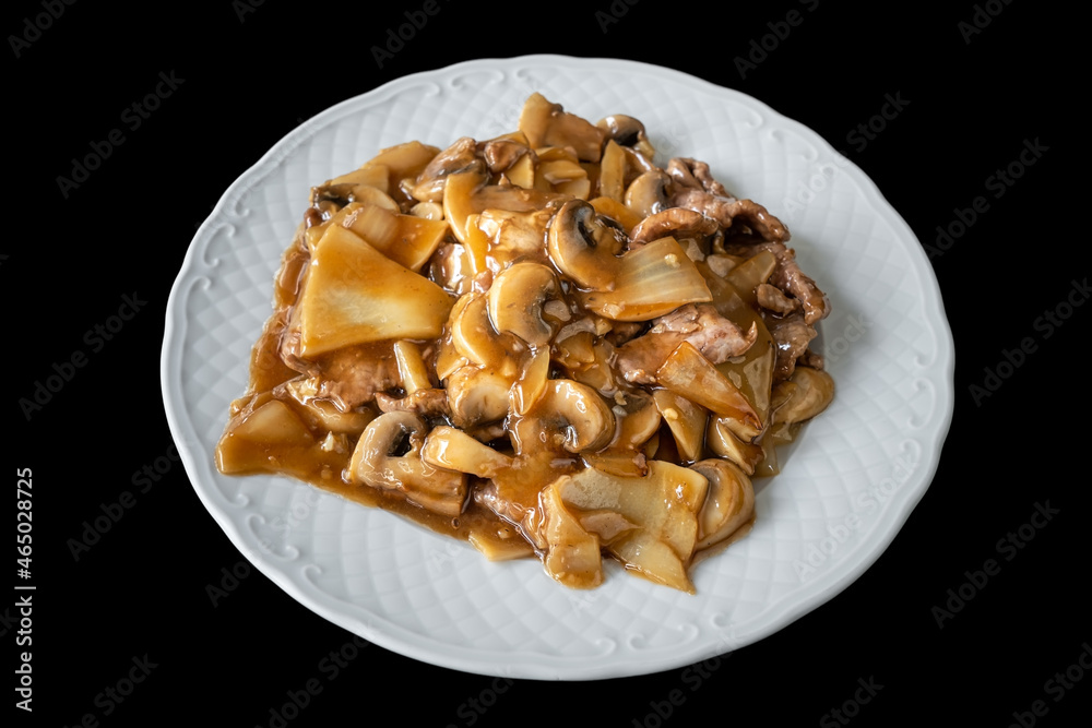 A traditional Chinese savory dish of cow stew and mushrooms in bamboo. On a black background, close-up. A traditional Chinese savory dish of cow stew and mushrooms in bamboo. On a black background, close-up.