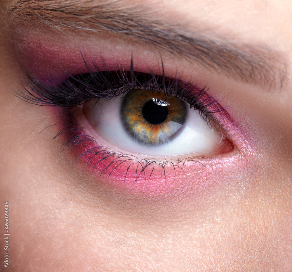 Closeup macro shot of human female eye with pink eyes shadows Closeup macro shot of human female eye with pink eyes shadows