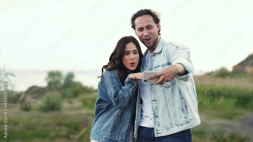 Smiling man and woman making selfie on the phone outdoors Smiling man and woman making selfie on the phone outdoors