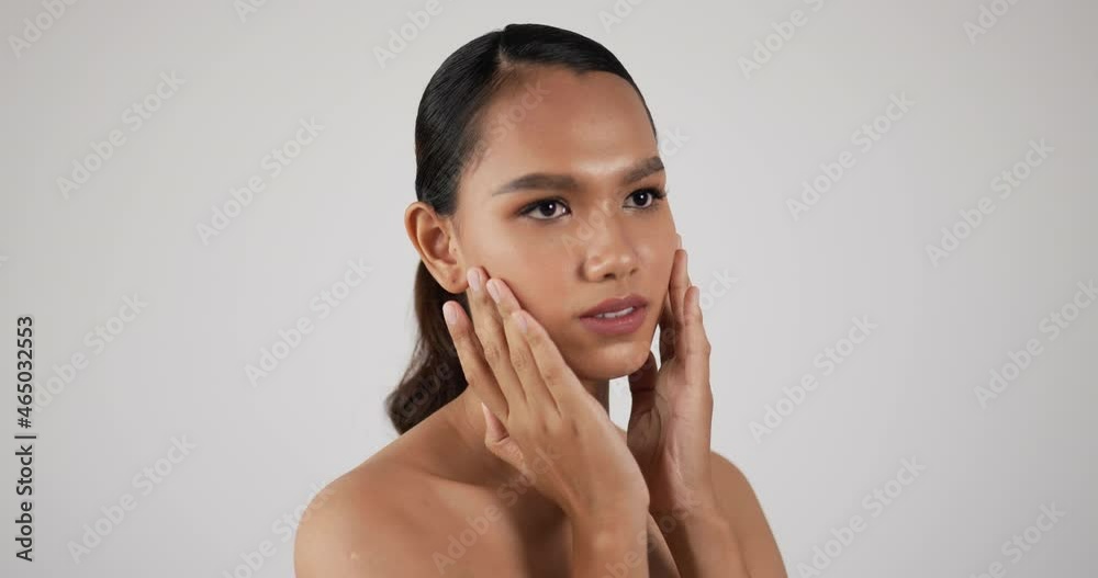 Happy attractive young woman touching pretty face after applying cream do make up Happy attractive young woman touching pretty face after applying cream do make up