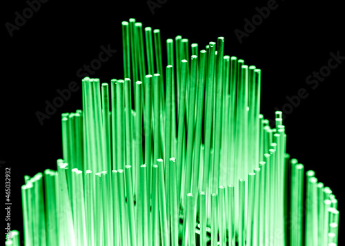 Green glowing glass rods on black background.